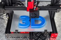 Red black 3D printer printing blue logo symbol on metal diamond plate future technology modern concept background