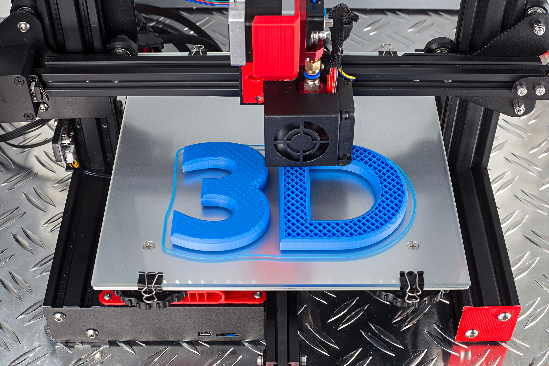 Red black 3D printer printing blue logo symbol on metal diamond plate future technology modern concept background